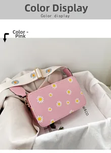 Detail view of pink crossbody bag with white daisy patterns and wide shoulder strap