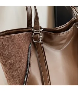 Detail of brown PU leather and corduroy patchwork tote bag with silver buckle and zipper