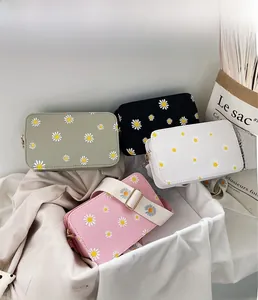 Close-up of small floral square bags in various colors with wide daisy patterned straps