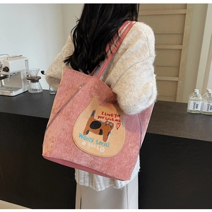 Détail du sac fourre-tout en velours côtelé rose avec écusson chat jaune et bandoulière