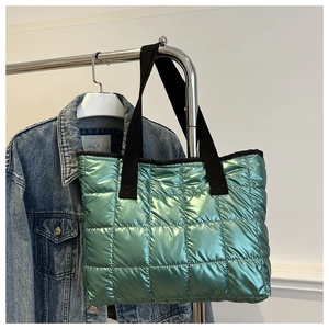 Détail du sac cabas matelassé vert métallisé brillant avec poignées en toile noire