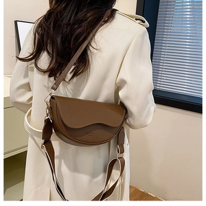 Sac selle en cuir marron avec rabat ondulé et deux options de bandoulière amovible