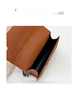 Detail of caramel quilted leather bag showing silver magnetic clasp and black interior