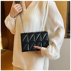 Chic black quilted crossbody bag with silver chain strap shown on a model for daily style