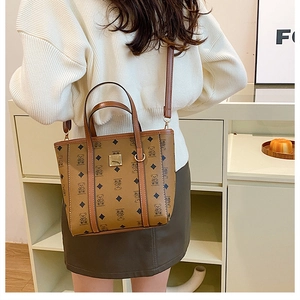 Vue détaillée du sac seau marron vintage avec motif ours et plaque logo en métal doré