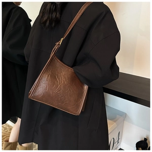 Detail of dark brown retro pleated shoulder bag showing PU leather texture and lettering