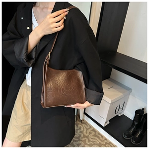 Deep brown leather shoulder bag styled with black blazer and khaki shorts