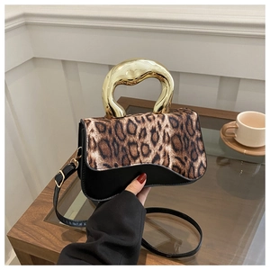 Close-up of leopard print handbag with chunky gold metal handle and black leather detail