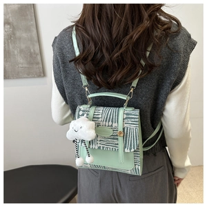 Detail of mint green plaid backpack with metal lock and cute cloud charm pendant