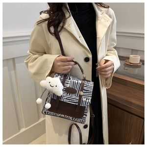 Detail of vintage blue checkered bag with brown leather flap and cute cloud charm
