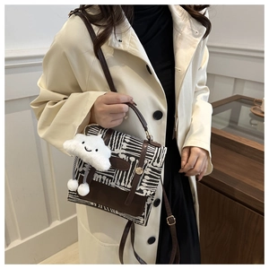 Detail of vintage plaid contrast crossbody bag with a cute white plush cloud charm