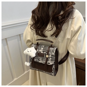 Detail of vintage canvas crossbody bag with white cloud plush charm and metal buckle