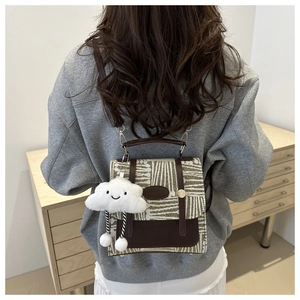 Detail of vintage plaid green backpack with leather straps and cute cloud charm