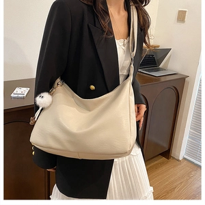 Minimalist beige crossbody bag styled with professional outfit in office setting