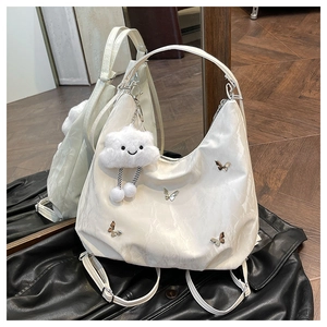 Detail of white half-moon bag with marble texture and silver butterfly charm