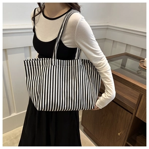 Détail d'un grand sac cabas en toile à rayures verticales noires et blanches avec anses