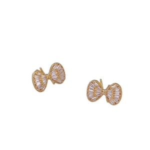 Elegant gold bow earrings with sparkling cubic zirconia stones on white background