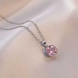 Vue macro d'un pendentif en pierre rose carrée sur une chaîne en argent fin