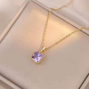 Vue détaillée du collier doré avec pendentif zircon violet carré sur coffret en cuir