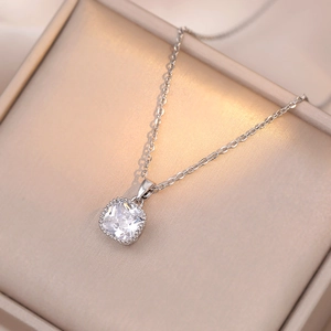 Gros plan d'un pendentif zircon sur chaîne en argent dans un écrin en satin de champagne