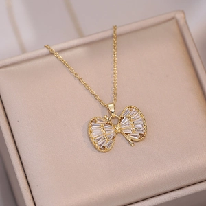 Elegant gold bow necklace with pavé zircon butterfly pendant on champagne jewelry box