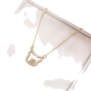 Collier doré avec pendentif ours évidé, zircons scintillants et lettre m centrale