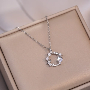 Collier argenté avec pendentif planète et étoiles sur une boîte à bijoux en satin