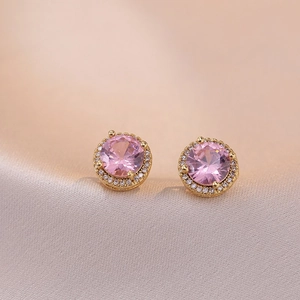 Boucles d'oreilles halo en zircon rose plaqué or rose sur fond de soie rose doux