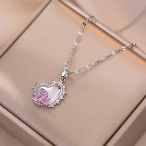 Collana con ciondolo a cuore rosa e cristalli su una scatola di gioielli dorata