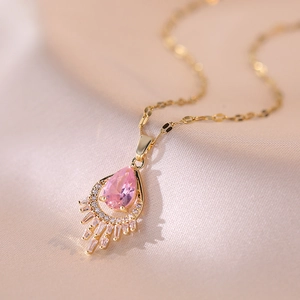 Elegant gold necklace with a pink teardrop zircon pendant and radiating baguettes