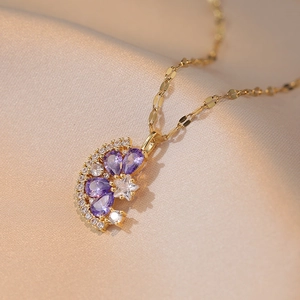 Collier élégant plaqué or avec zircons violets en forme de poire sur fond de satin