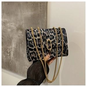 Close-up of leopard print shoulder bag with gold metal chain and oval clasp detail
