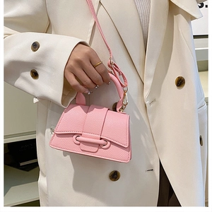 Detail of pink litchi grain leather mini bag showing flap closure and handle