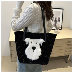 Schwarze Tote Bag mit weißem Plüschhund-Patch und Punkten, getragen von Model