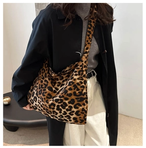 Detail of trendy leopard print canvas shoulder bag worn by model in a minimalist setting