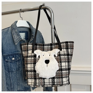 Dettaglio della borsa tote in tweed a scacchi con patch a forma di cane di peluche