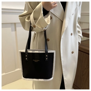 Women's two-tone faux shearling bucket bag with black trim and elegant top handles