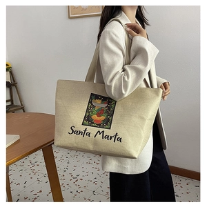 Detail of a beige canvas tote bag with colorful Santa Marta portrait print and wide straps