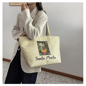 Side view of beige canvas tote bag with Santa Marta tropical woman print and wide straps