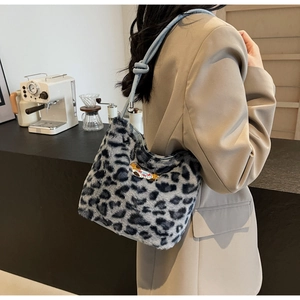 Close-up of leopard print faux fur bag with cute puppy embroidery and blue leather strap