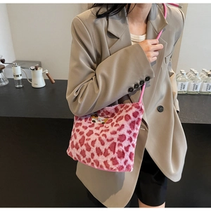 Detail of pink leopard plush shoulder bag with a cute bear patch worn by a model
