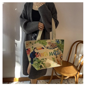 Detail view of canvas tote bag featuring Santa Marta tropical print and woven straps