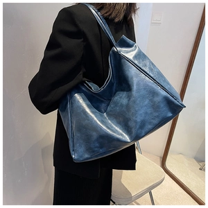Vue détaillée du grand sac cabas bleu marine avec texture cirée porté par un mannequin