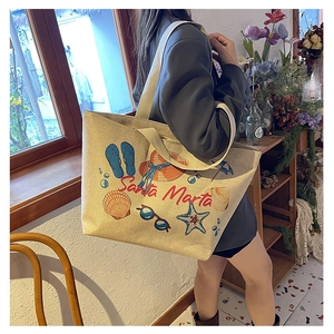 Detail showing high-capacity canvas tote bag with Santa Marta beach theme print and straps