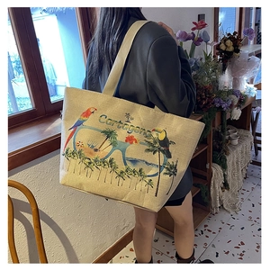Lifestyle shot of large canvas tote bag with Cartagena tropical parrot embroidery detail