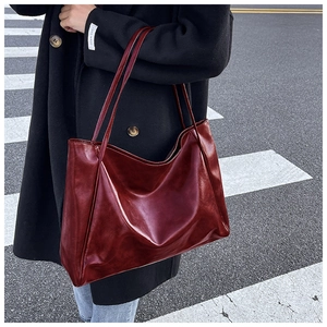 Détail d'un cabas bordeaux brillant en cuir ciré avec une texture naturelle souple