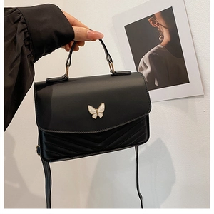 Schicke schwarze Stepptasche mit Perlen-Schmetterlingsschnalle in modischer Umgebung