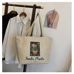 Detail of artistic Santa Marta print on a cream canvas tote bag with ethnic embroidery