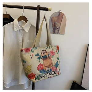 Detail of canvas tote bag with Cartagena sloth print and woven shoulder strap