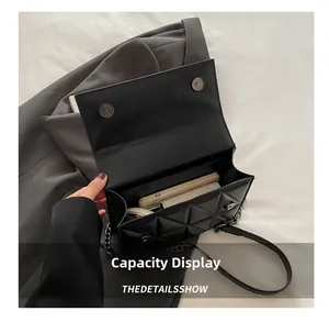Top view of black quilted crossbody bag interior showing phone and cosmetics capacity